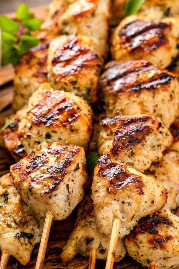 Wood skewers with bite sized pieces of grilled chicken souvlaki on them.