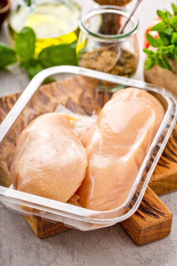 Raw chicken breasts in a glass tupperware