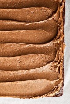 Swirls of homemade chocolate buttercream frosting spread on top of a chocolate cake.