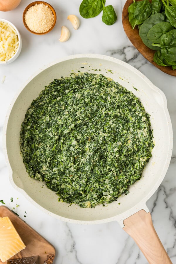 Creamy spinach with melty cheeses in the pot. 