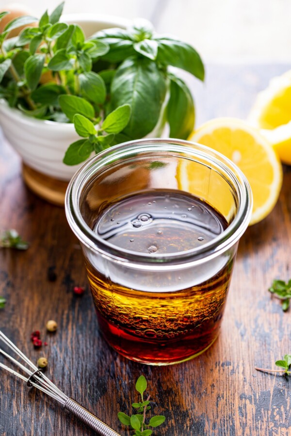 Olive oil and red wine vinegar in a glass jar.
