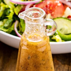 Greek seasoned dressing in a glass container.