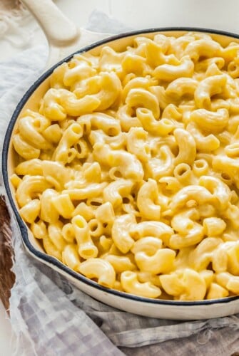 A large white skillet is filled with homemade mac and cheese.