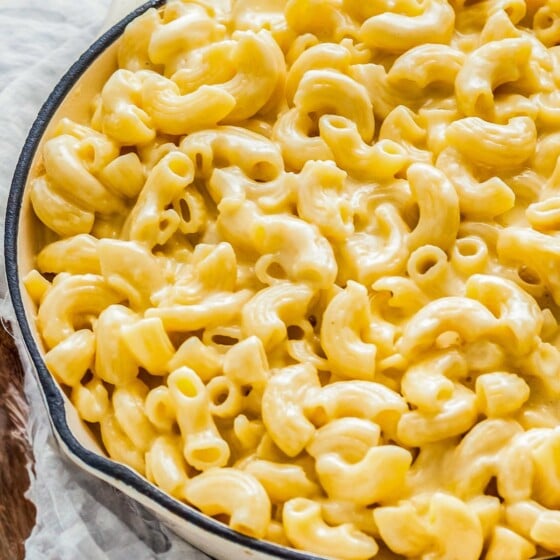 A large white skillet is filled with homemade mac and cheese.