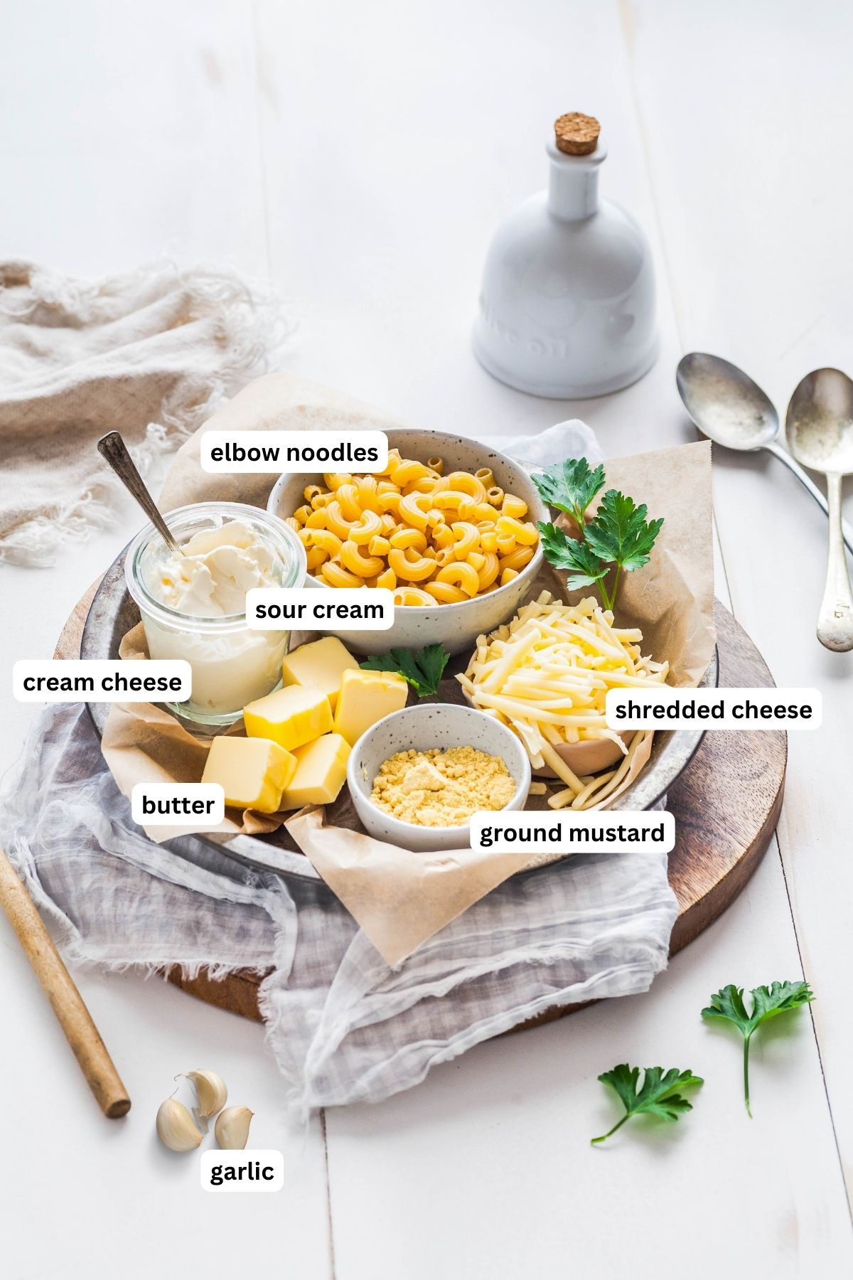 The ingredients are listed from top to bottom: elbow noodles, sour cream, cream cheese, butter, ground mustard and shredded cheese. 