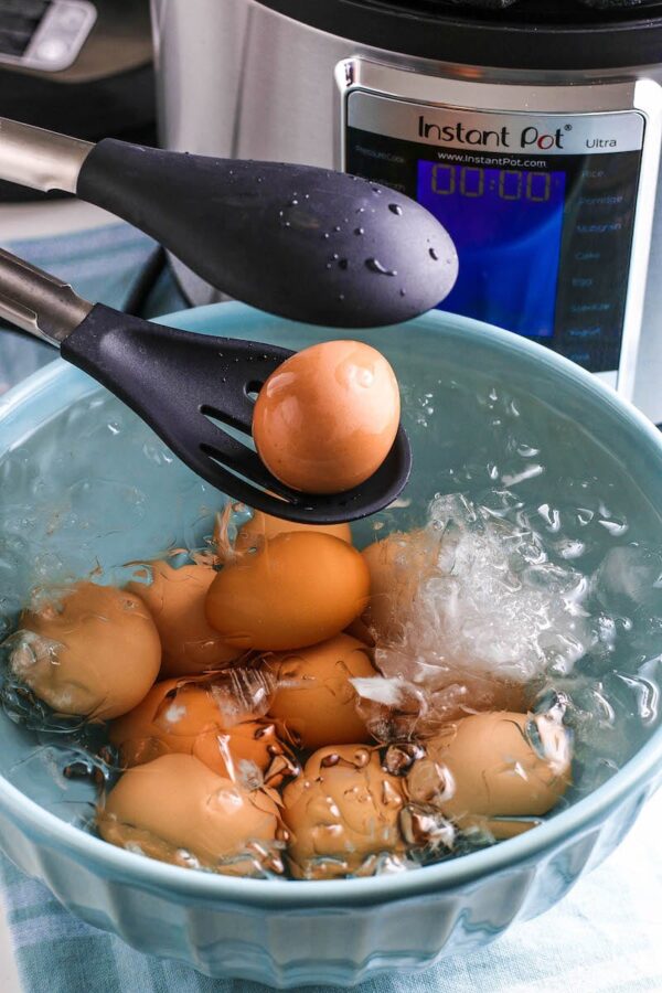 Hard boiled eggs being added to an ice bath.