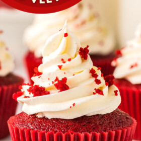 Red velvet cupcake topped with cream cheese frosting and cupcake crumbs.