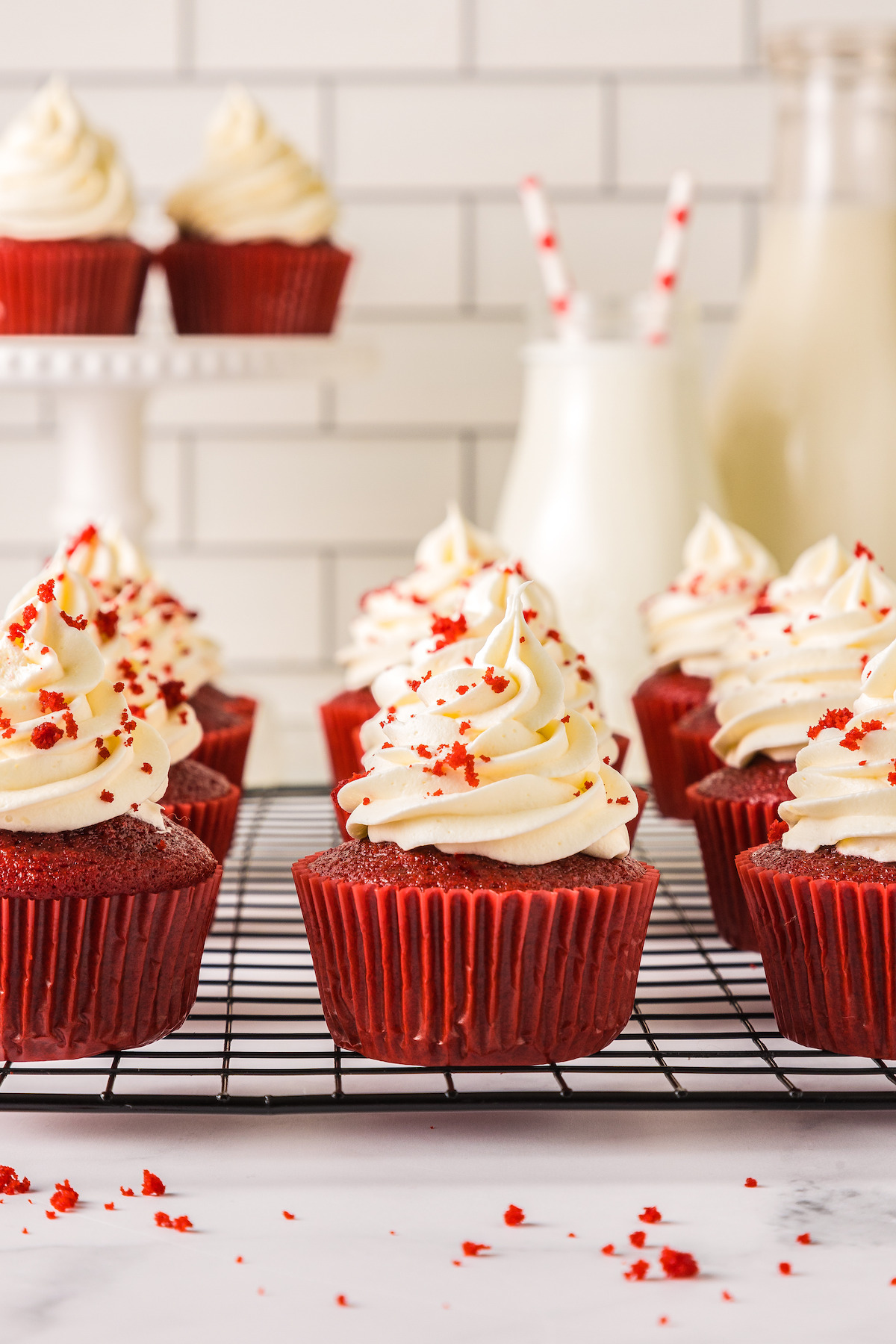 Red velvet cupcakes with cream cheese frosting on top.