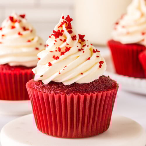 Frosted cupcakes with red velvet crumbs on top.