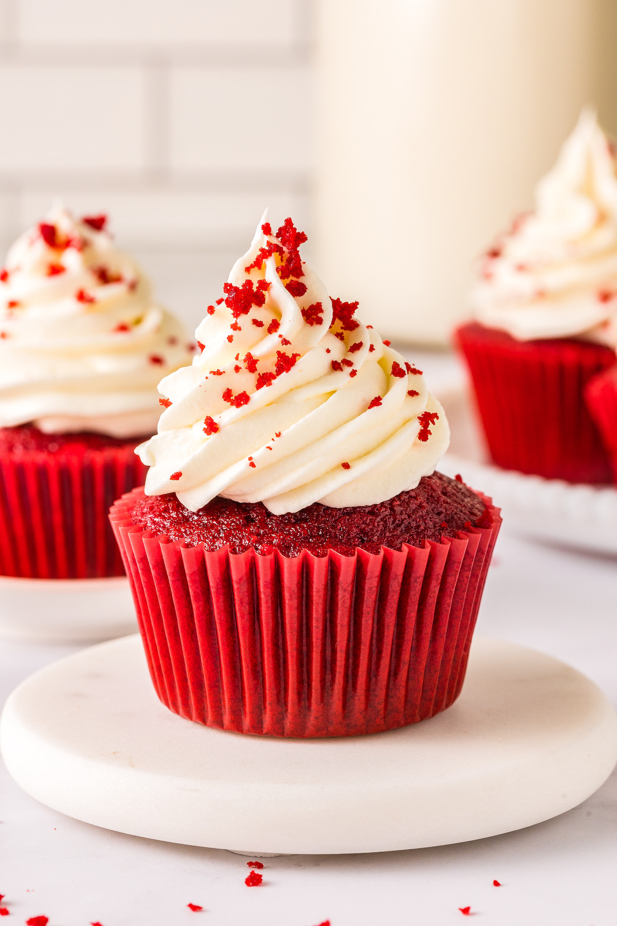 Frosted cupcakes with red velvet crumbs on top.