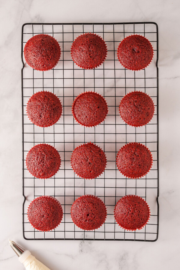 Baked red velvet cupcakes on a cooling rack.