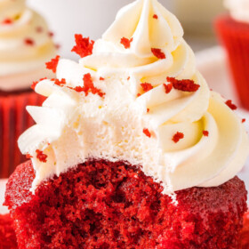 A red velvet cupcake with a bite taken out of it.
