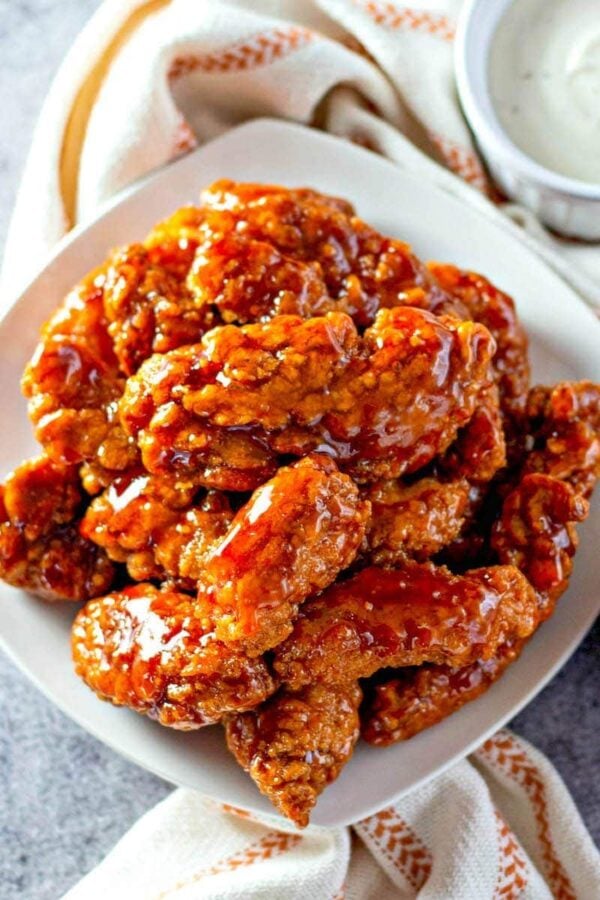 Sticky Chicken Tenders on a white plate.