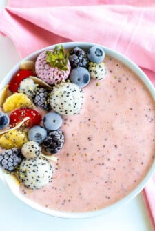 A strawberry smoothie bowl with mixed berry and fruit toppings.