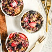 Blackberry cobbler served in 3 dishes and topped with sliced strawberries.