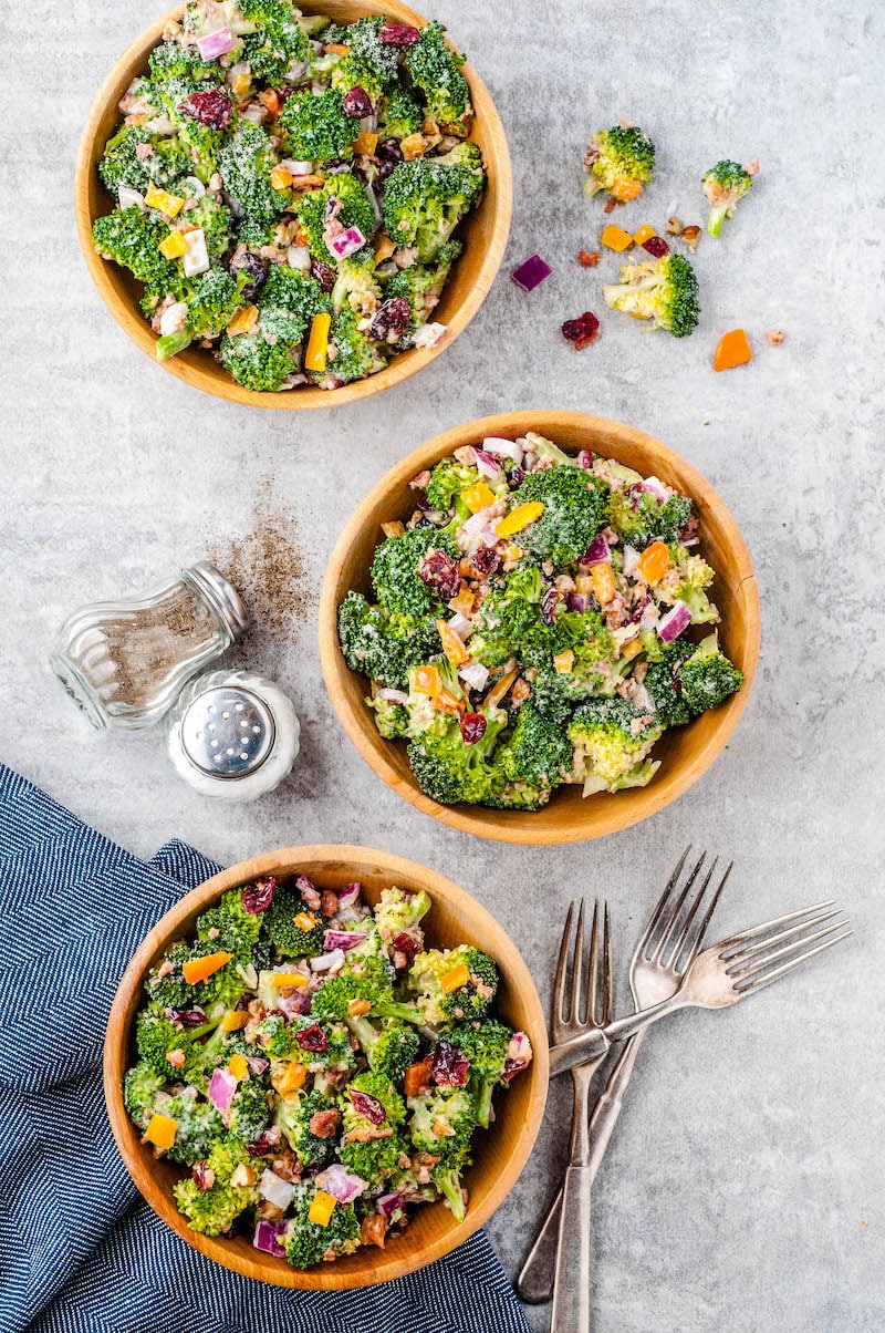 Colorful broccoli salad served in 3 bowls.