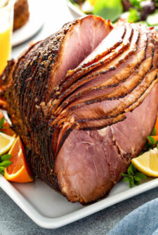 Crockpot ham on a plate with fresh fruit.