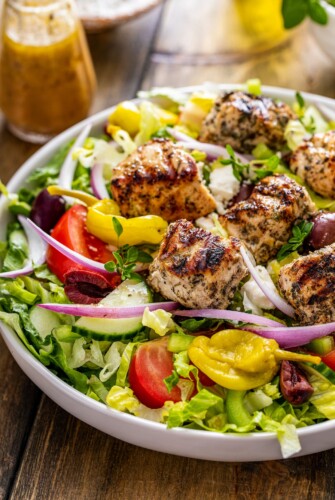 Chicken served over Greek salad.