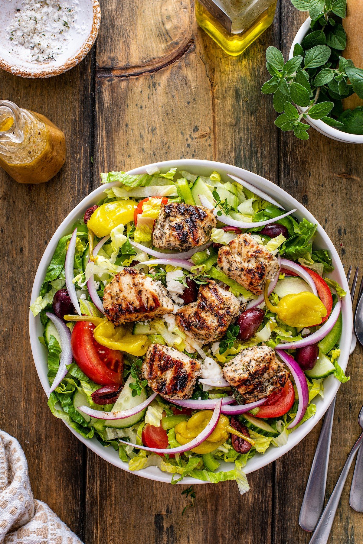 Bowl of Greek salad with peppers added in.