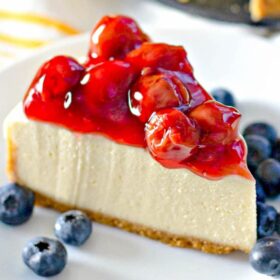 Up close image of a slice of cheesecake with cherries.
