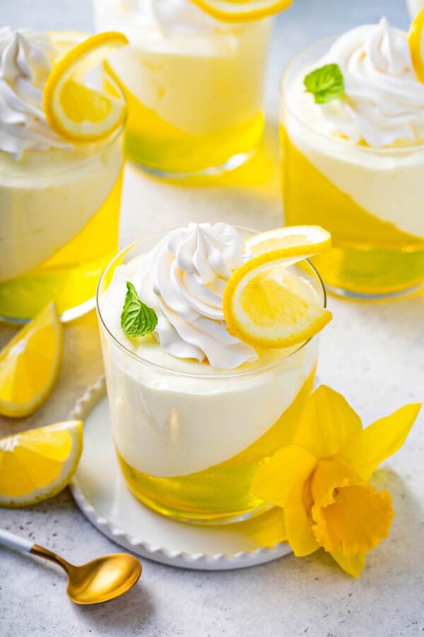 Lemon Mousse Jello Cups on plates with spoons.