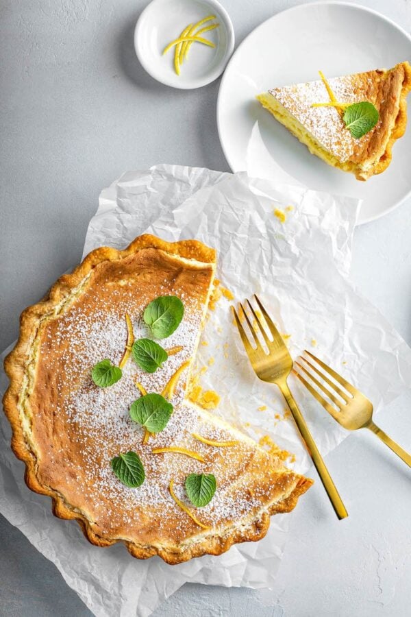 Tennessee Lemon Pie on parchment paper, sliced into pieces with a fork. 