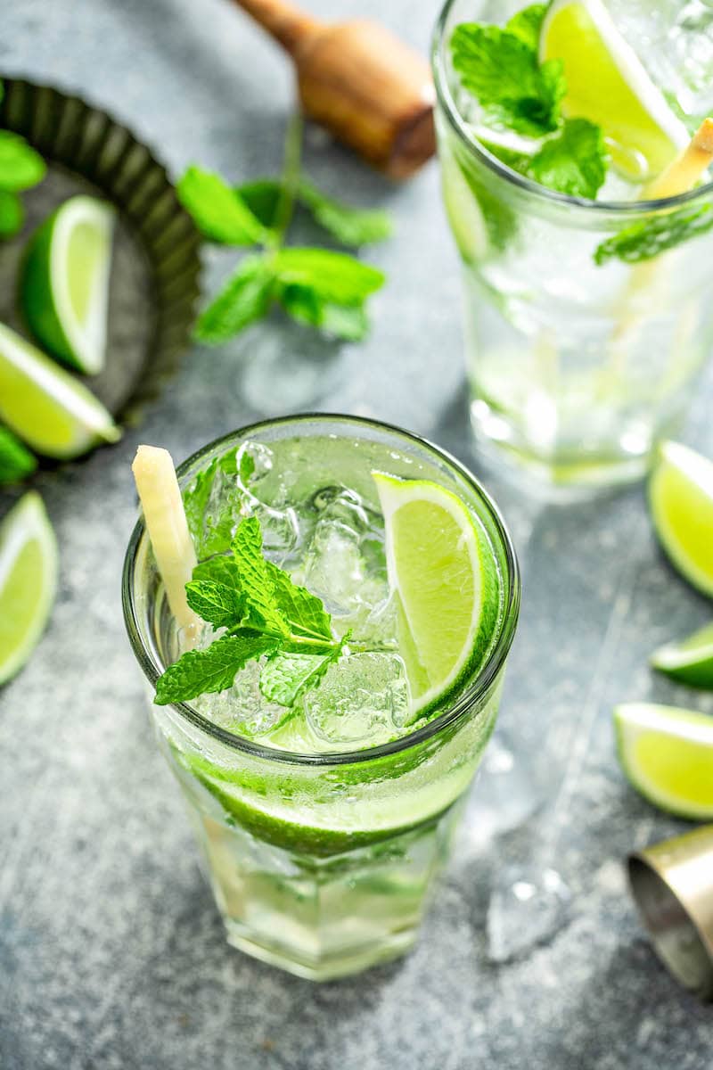 Overhead image of two mojitos with lime and mint.