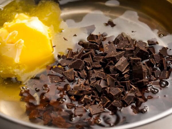 Chocolate, eggs and oil are melting together in a saucepan. 