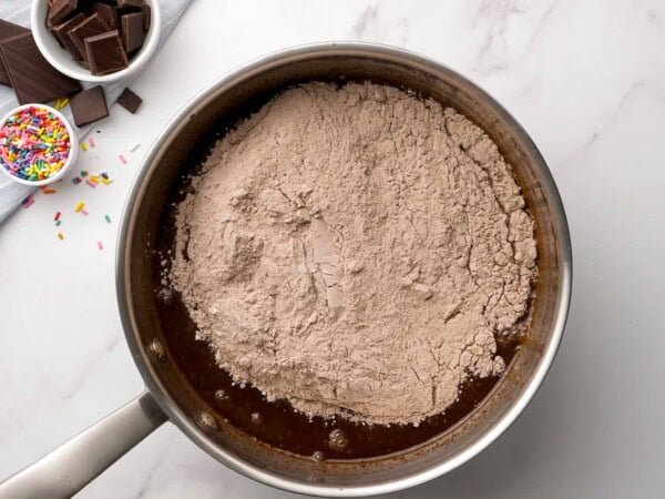 Dry ingredients have been added to the saucepan. 