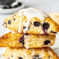 A stack of three blueberry scones drizzled with vanilla glaze