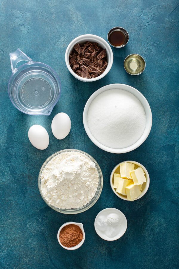 Ingredients for cake in bowls on a blue background.