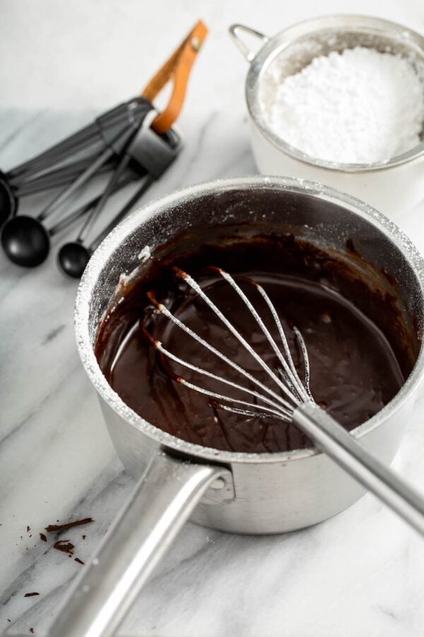 chocolate sauce in a sauce pan with whisk stirring to combine.