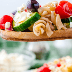 Pinterest image of Greek Pasta Salad on a spoon with wording for pinterest.