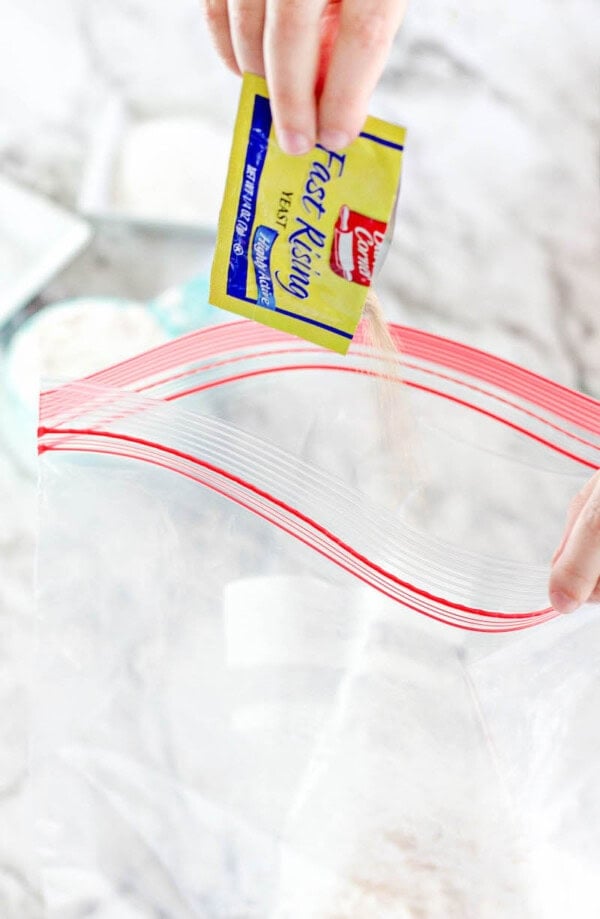 Pouring yeast into a plastic ziplock bag.