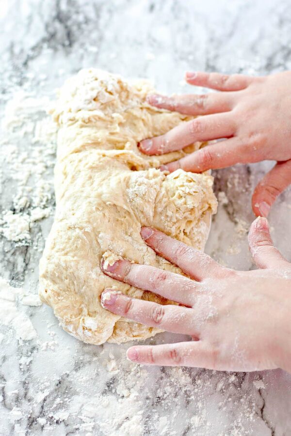 Kneading bread dough with flour by hand.