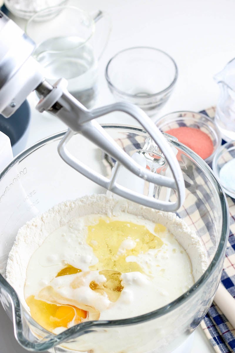 White cake batter in a stand mixer with eggs and vanilla. 