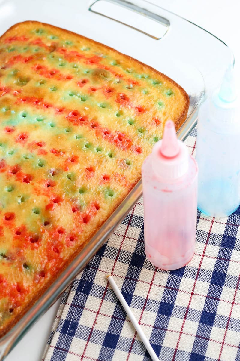 Poke cake with red and blue jello squeezed in the holes.