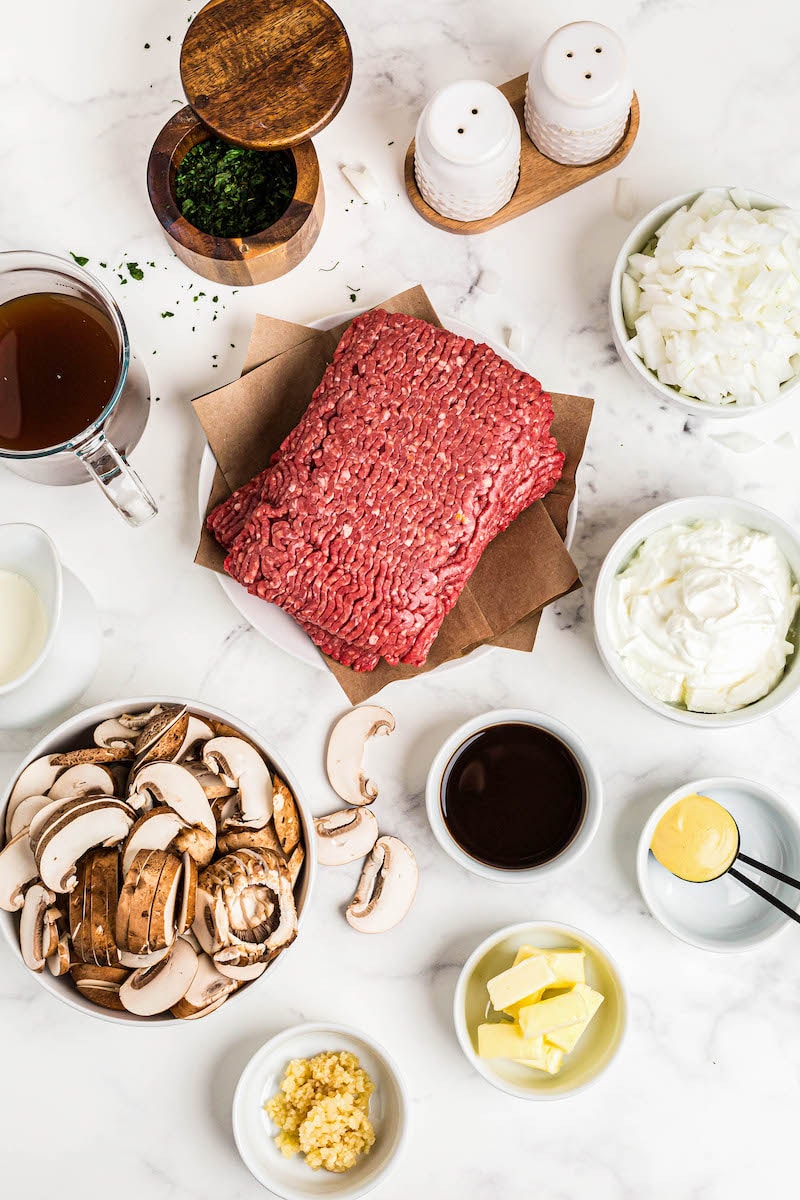 Ingredients for beef stroganoff on a marble counter.