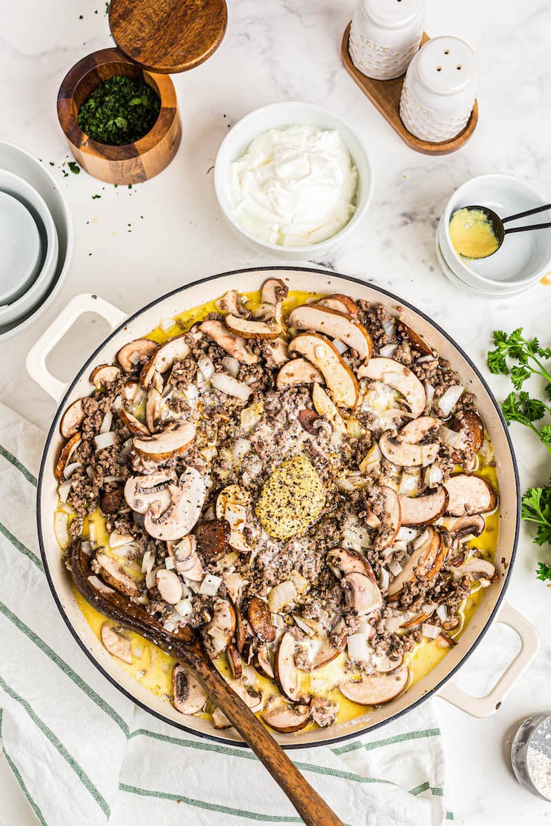 Mushrooms and sauce in a pan with beef.