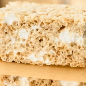Close-up of a thick, homemade brown butter Rice Krispie treat, showing its crispy texture and gooey marshmallow layers. Text reads: Quick and Easy Brown Butter Rice Krispie Treats. The Novice Chef.