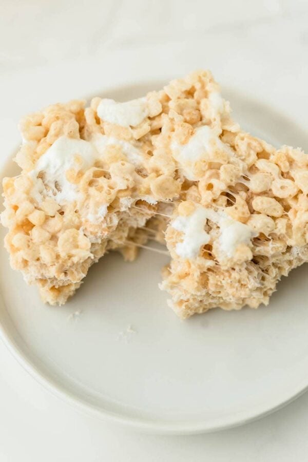 Marshmallow cereal bar on a plate torn in half.