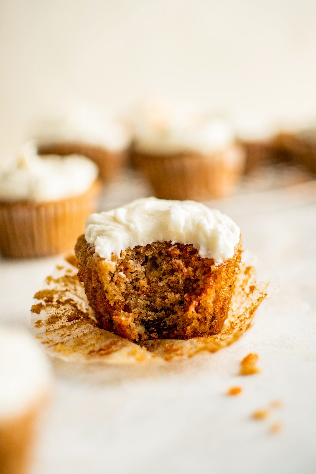 A carrot cupcake with a bite taken out of it.