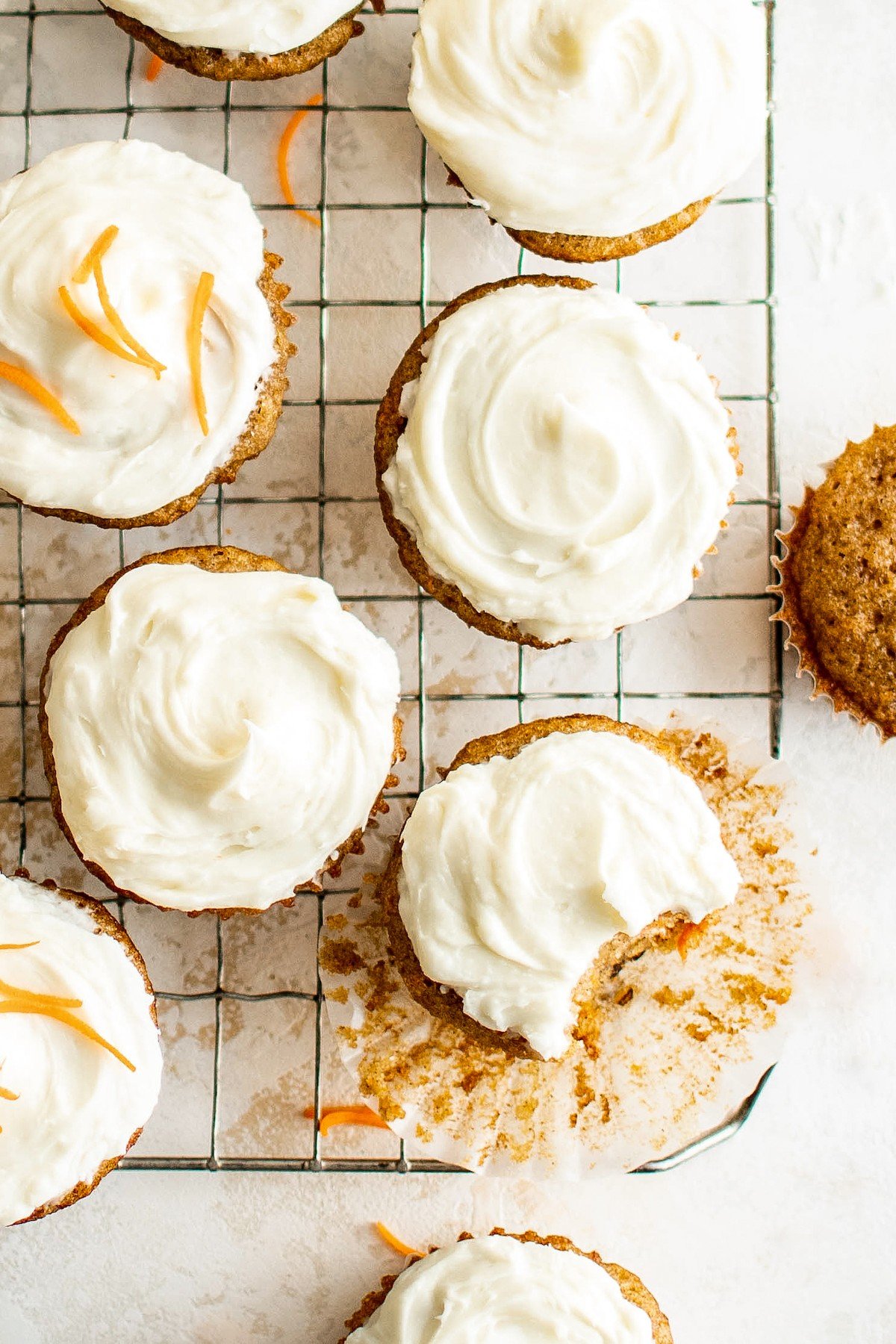 Carrot cake cupcakes on a wire rack.