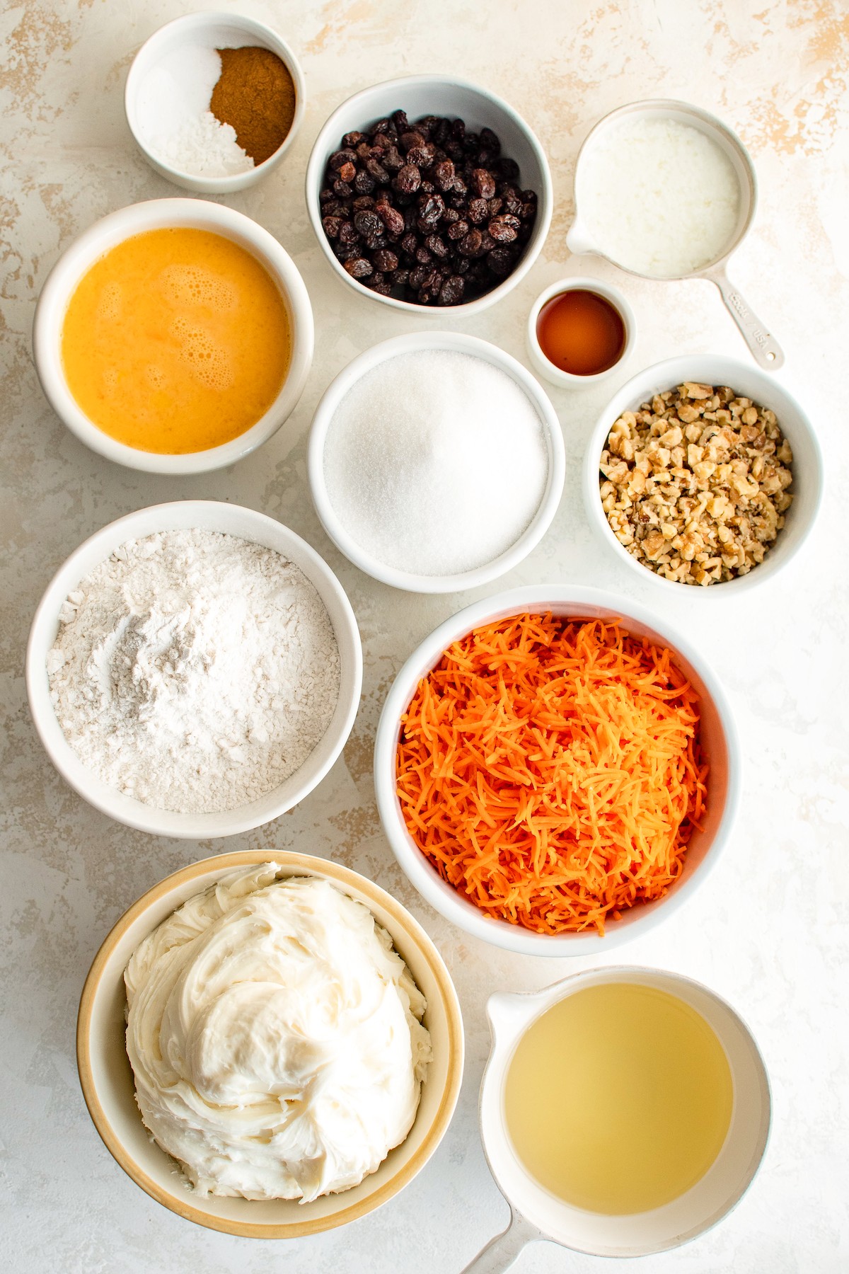 Ingredients for carrot cupcakes measured and arranged on a work surface.