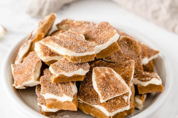 Cinnamon sugar toffee stacked on a white plate. 