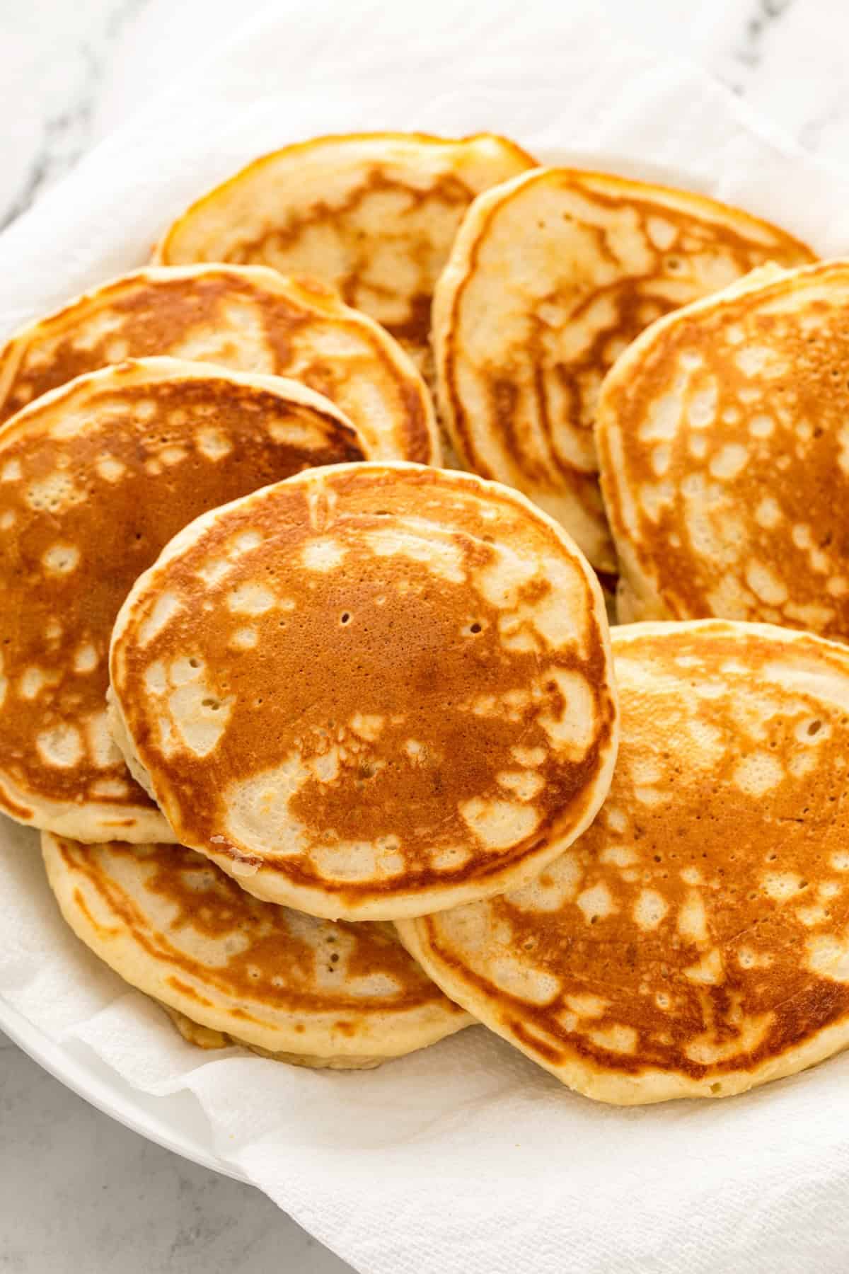 A large platter topped with fluffy homemade pancakes.