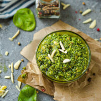 Pesto in a glass bowl with sliced almonds on top.