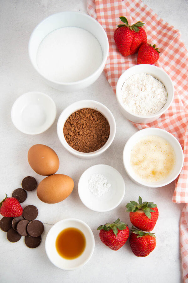 Ingredients in white bowls with a pink checkered napkin.