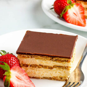 A Slice of No Bake Chocolate Eclair Cake with Strawberries on a Plate