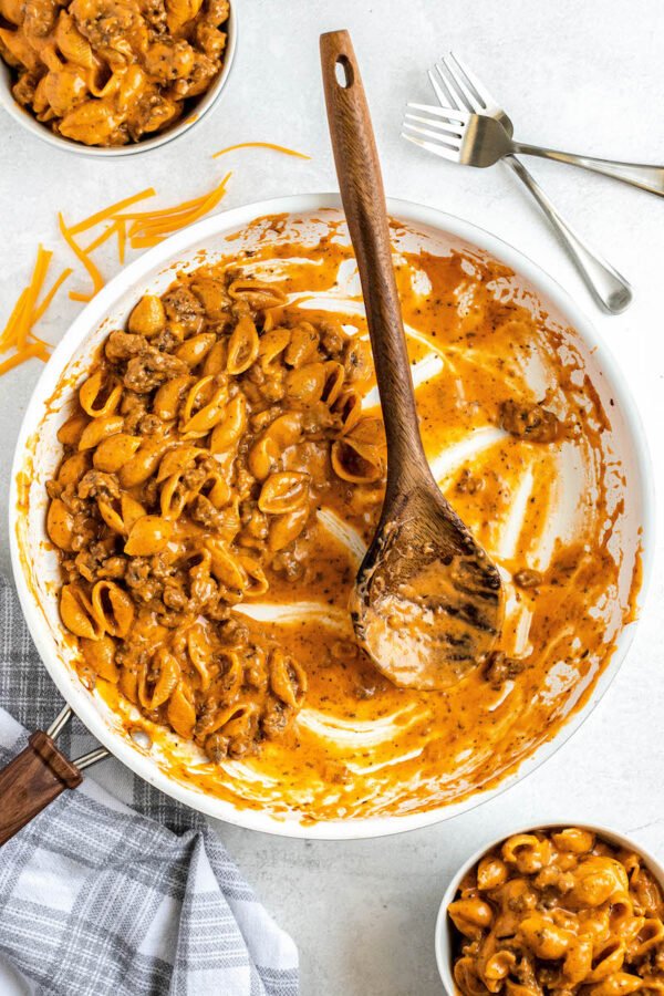 A pot of homemade hamburger helper with a wooden spoon.